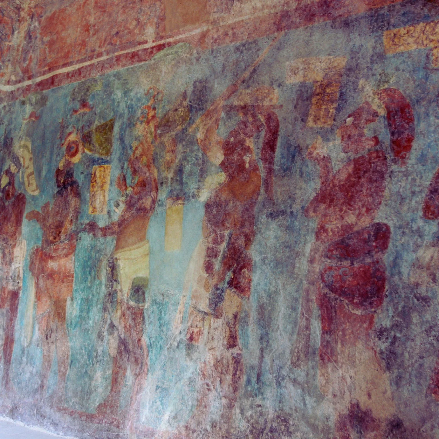 Maya mural at Bonampak in Chiapas, Mexico, showing musicians, dancers, and ritual procession in red and blue pigments.
