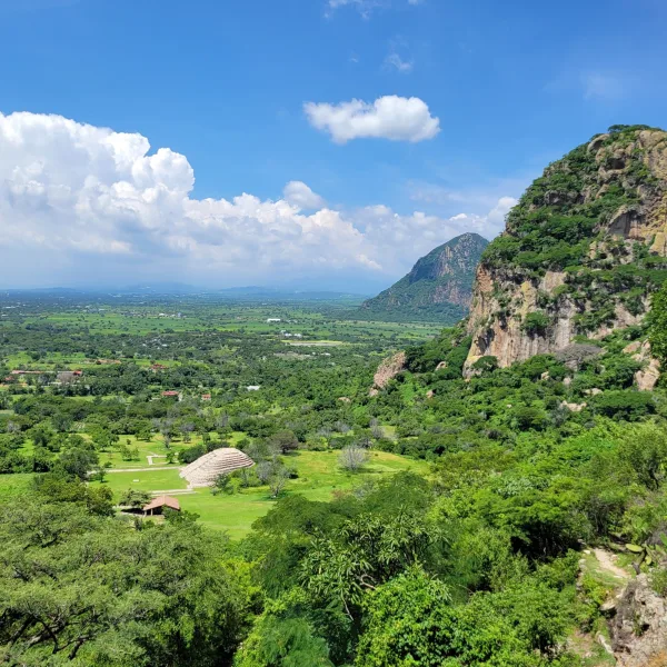 Aerial view of Chalcatzingo ruins in Morelos, Mexico, showing a ceremonial platform and the surrounding valley with Cerro Chalcatzingo in the background