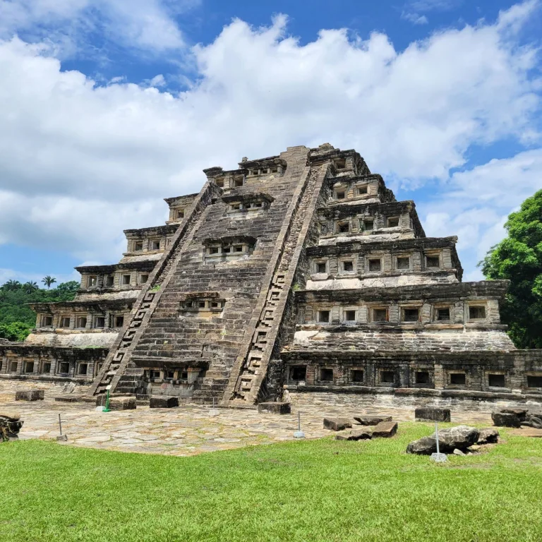 Pyramid of the Niches at El Tajín in Veracruz, Mexico, Totonac ceremonial pyramid with multiple tiers and rows of recessed niches under a blue sky.