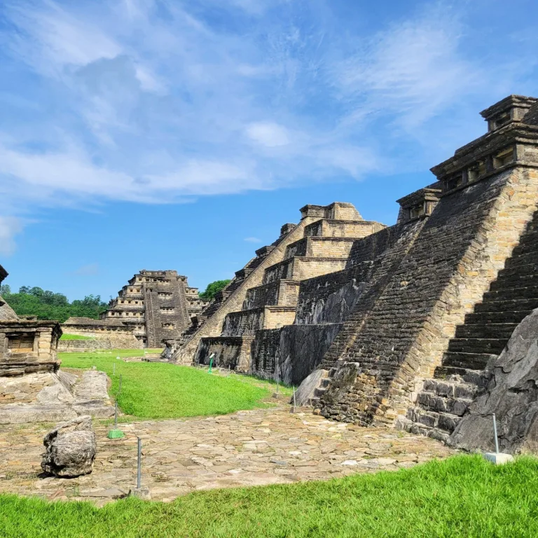 Stepped temples and platform structures at El Tajín with the Pyramid of the Niches rising in the distance
