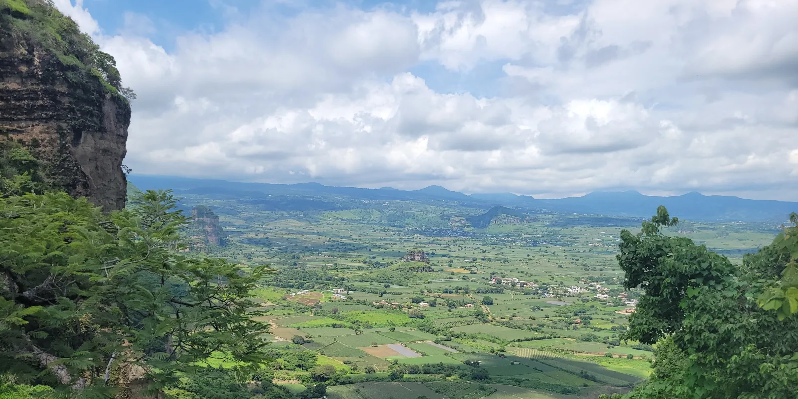 Panoramic view from El Tlatoani ruins showing cliffs, terraces, and the Tlayacapan valley below in Morelos, Mexico