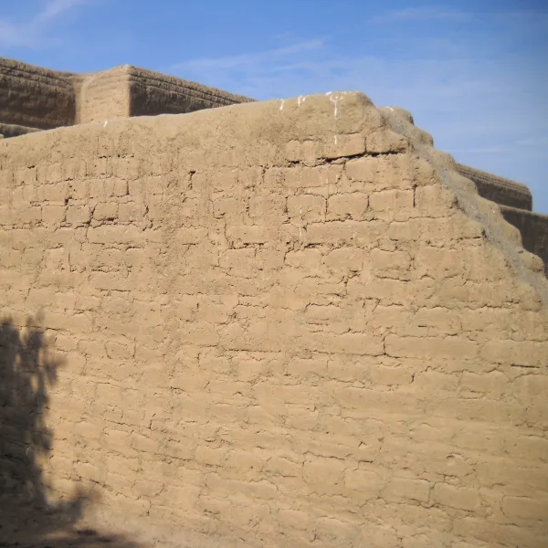 Close-up of adobe brick walls at Huaca Arco Iris (El Dragón), highlighting traditional construction techniques and stepped architecture