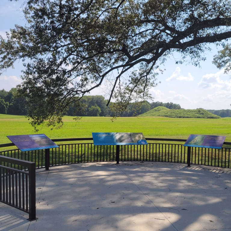 Interpretive viewing platform with informational signs at Angel Mounds State Historic Site in Indiana, looking across the central plaza toward the main mound.