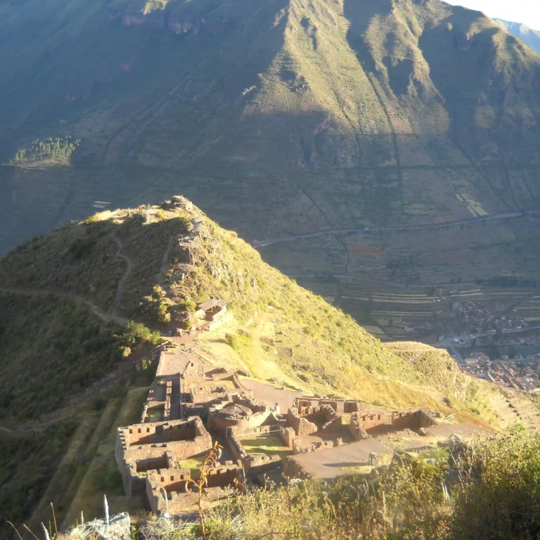 Aerial-style view of Pisac’s ruins winding along a mountain ridge, with town below