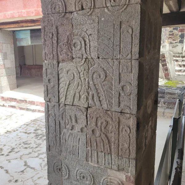 Close-up of carved stone column at Teotihuacan featuring repeating avian motifs and symbolic patterns from the Palace of Quetzalpapálotl.
