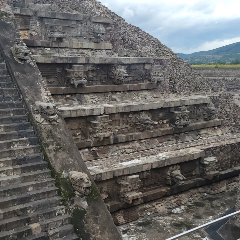 Detailed view of the Temple of the Feathered Serpent at Teotihuacan, showing rows of carved serpent heads and step platforms.
