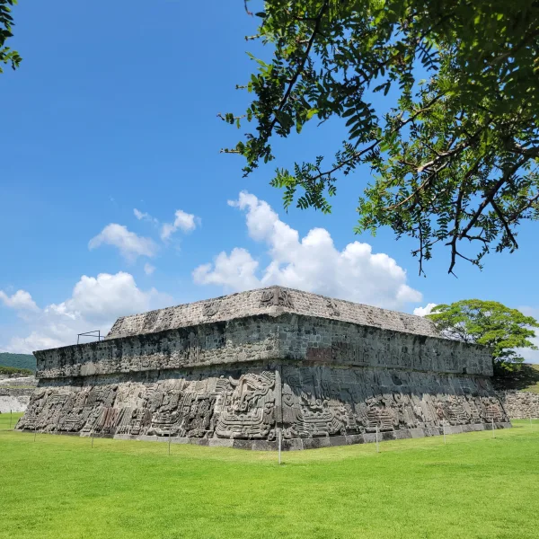 Exterior view of the Temple of the Feathered Serpents at Xochicalco, covered in carved reliefs of plumed serpents and deities.
