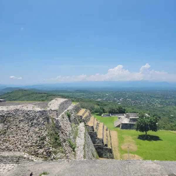 Terraced stone walls and panoramic overlook from the upper levels of Xochicalco, facing the lush Morelos Valley.