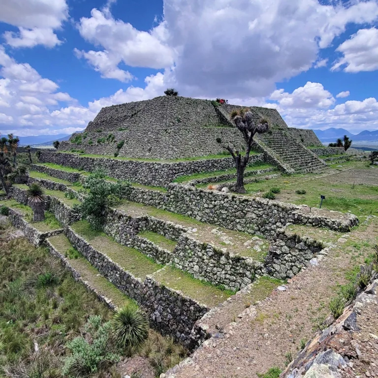 Pirámide del Mirador at Cantona in Puebla, Mexico, with broad stone terraces, a central staircase, and surrounding platforms of Plaza Oriente.
