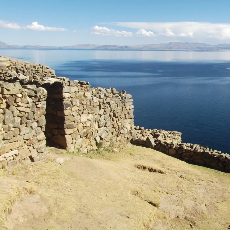 Stone walls of the Chincana Labyrinth on Isla del Sol, Bolivia, overlooking the blue waters of Lake Titicaca.