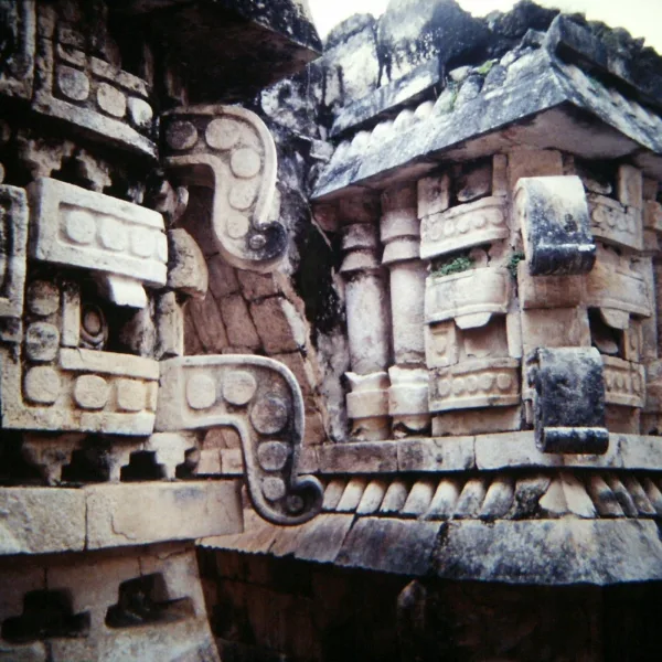 Close-up of Labna Puuc style architecture Yucatan Mexico. Intricate Chaac rain god stone carvings and mosaic façade details from Maya ruins on the Puuc Route.