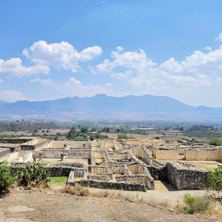 Overhead view of the Palace of the Six Patios at Yagul in Oaxaca, Mexico, with the Tlacolula Valley and surrounding mountains in the background.