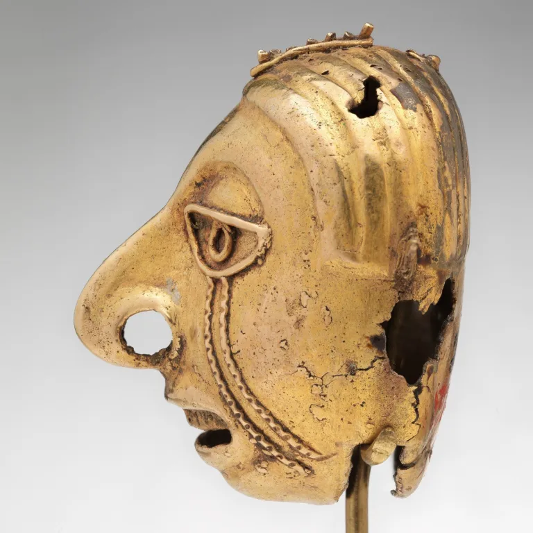 Aztec gold head-shaped bell cast using the lost-wax method, used as a musical ornament in elite regalia.