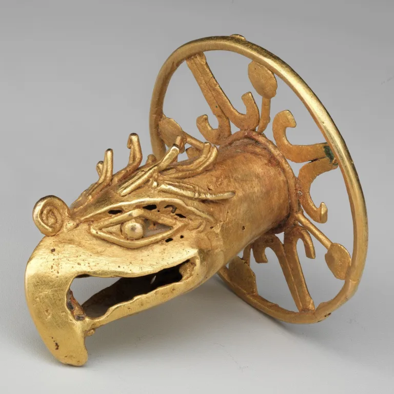 Aztec tubular gold ornament cast as an eagle's head, representing the sun, military power, and elite regalia.