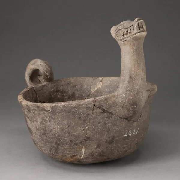 Mississippian ceramic effigy bowl (1000–1400) from Arkansas, shaped like the Underwater Serpent (Piasa). The vessel features a distinctly upturned neck with incised details and a coiled tail, symbolizing a powerful deity.