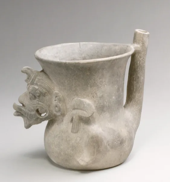 Early Zapotec fine grayware bridge-and-spout jar (3rd–1st century BCE) from Monte Albán, Oaxaca, Mexico. The vessel is decorated with a high-relief figure, possibly representing the Old God (Huehuetotl) or the Wind God (Ehecatl).