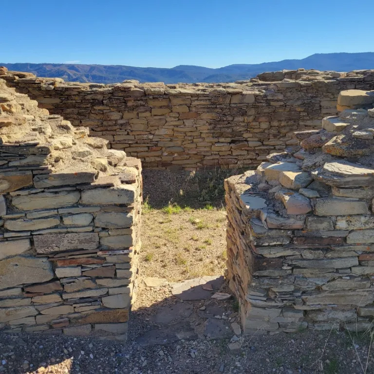 View through a narrow entryway gap in the thick, double-layered stone masonry walls of the Great House Complex.
