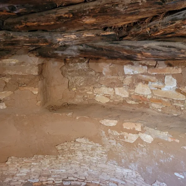 Interior view of the reconstructed, circular, subterranean kiva, showing the masonry benches, pilasters, and a central fire pit (sipapu is not visible).