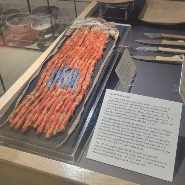 Angled view of a museum display case holding the original Mcaw Fiber Sash, a rare example of Ancestral Puebloan textile technology.