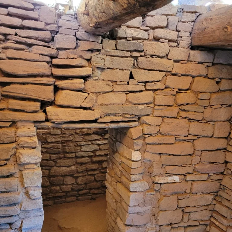 Interior view looking up at the heavy, wooden log rafters and beams that support the reconstructed roof