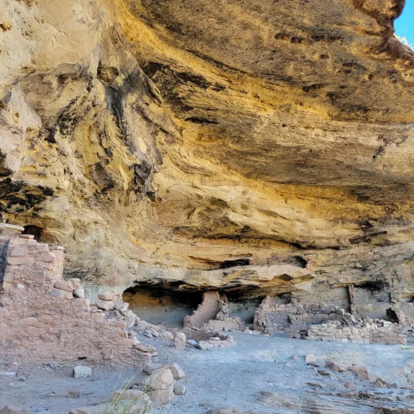 Stone masonry room walls of Five Kiva Pueblo built beneath a large sandstone overhang in Utah.