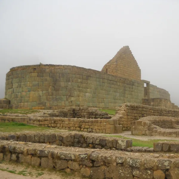 Side view of the Temple of the Sun at Ingapirca in Canar Ecuador with stone foundations in the foreground.