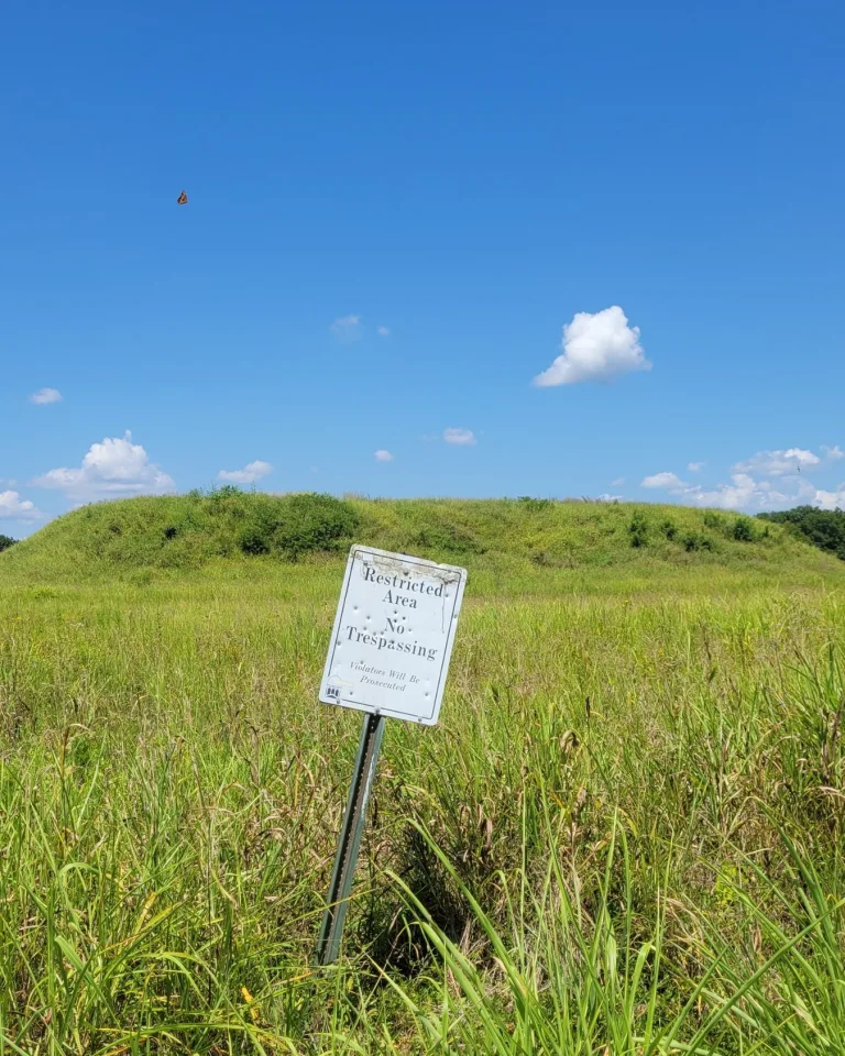 No trespassing sign posted between two mounds at Kincaid Mounds, Illinois, protecting the site from disturbance.