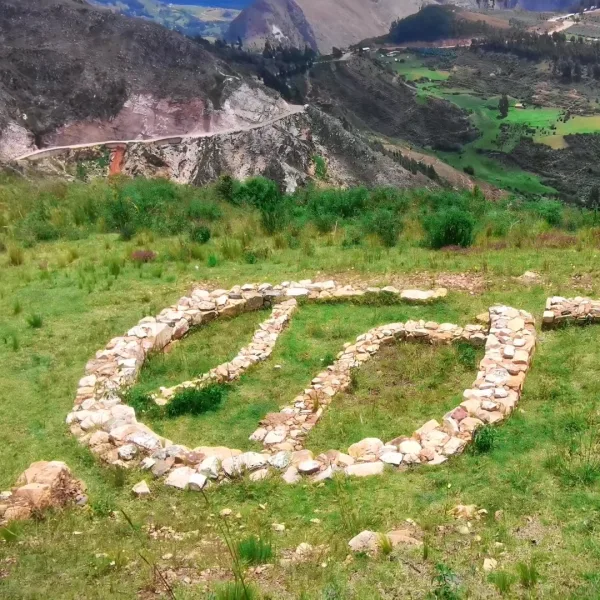 El Recinto Circular at Cerro Miraflores near Huamachuco, Peru, with low stone walls set on a grassy hillside above the valley.