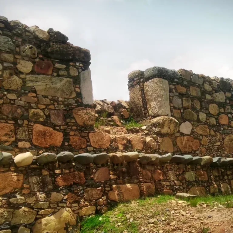 Stone wall remains at Cerro Miraflores near Huamachuco, Peru, with large fitted blocks and smaller masonry stones forming adjoining wall sections.