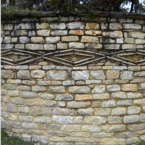 Stone wall at Kuélap in Chachapoyas, Peru, with a carved diamond frieze pattern.
