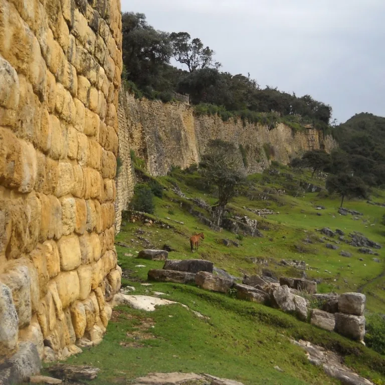 Outer wall of Kuélap in Chachapoyas, Peru, with a horse below the stone fortification for scale.