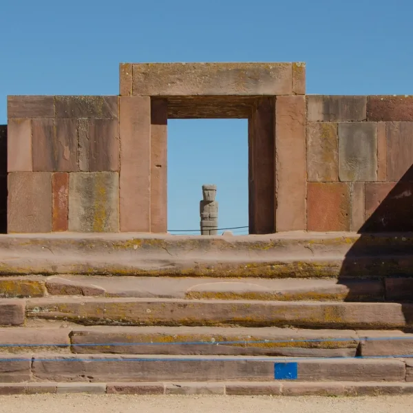 Doorway of the Kalasasaya temple at Tiwanaku in Bolivia framing a standing monolith in the distance.