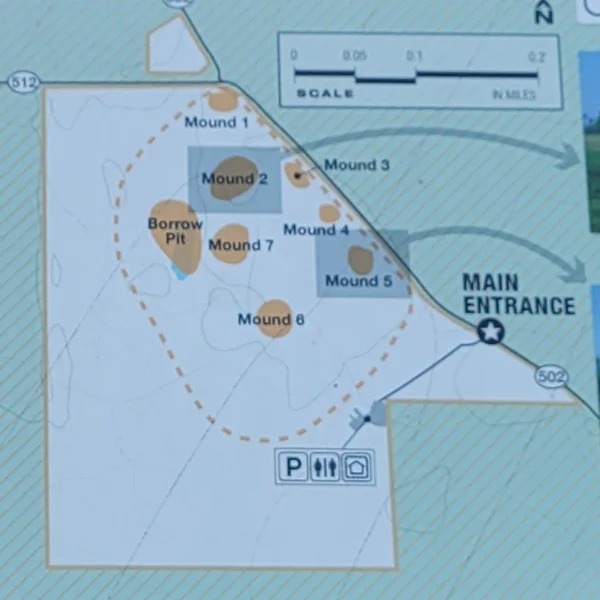 Site map of Towosahgy State Historic Site in Missouri, showing the main entrance, numbered mounds, borrow pit, walking route, scale, parking, restrooms, and shelter.