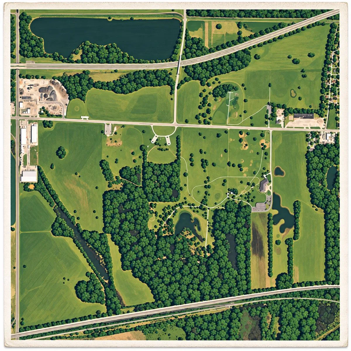 Illustrated aerial site map of Cahokia Mounds in Illinois, showing the Mississippian mound complex, open plazas, wooded areas, roads, ponds, and surrounding landscape.