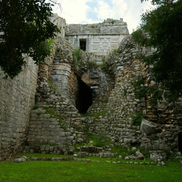 Upper building of the Las Monjas complex at Chichén Itzá in Yucatán, Mexico, with geometric stone decoration visible above a partly ruined lower structure.