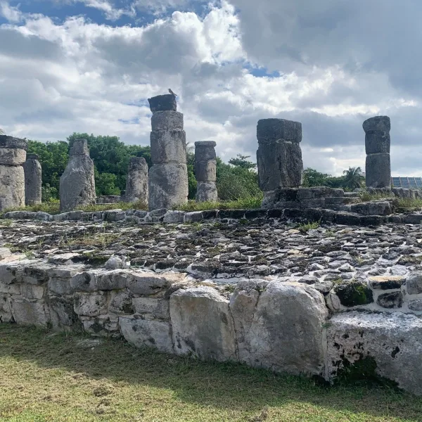 Stone columns stand on a low masonry platform at the Maya archaeological site of El Rey in Cancún, Quintana Roo, Mexico.