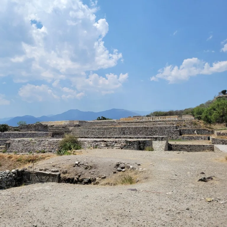 Centro Cívico Religioso at Yagul in Oaxaca, Mexico, showing broad stone terraces, stepped platforms, and plastered architectural remains beneath the surrounding hills.