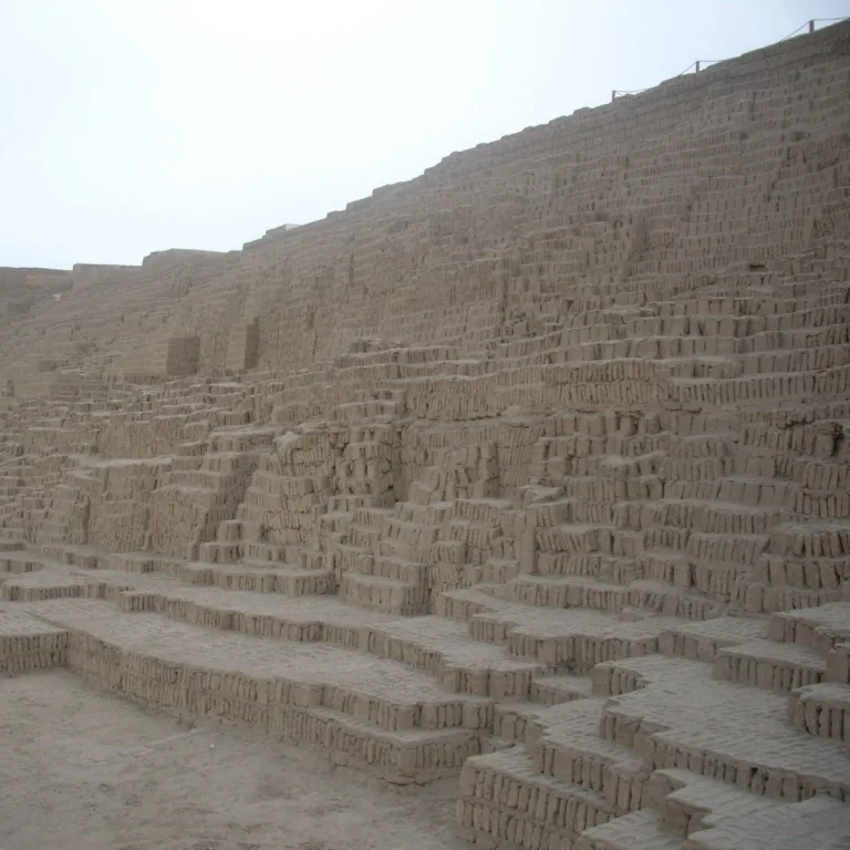 The Gran Pirámide at Huaca Pucllana in Miraflores, Peru, showing broad adobe platforms, stepped retaining walls, and vertically arranged bricks extending up the monumental structure.