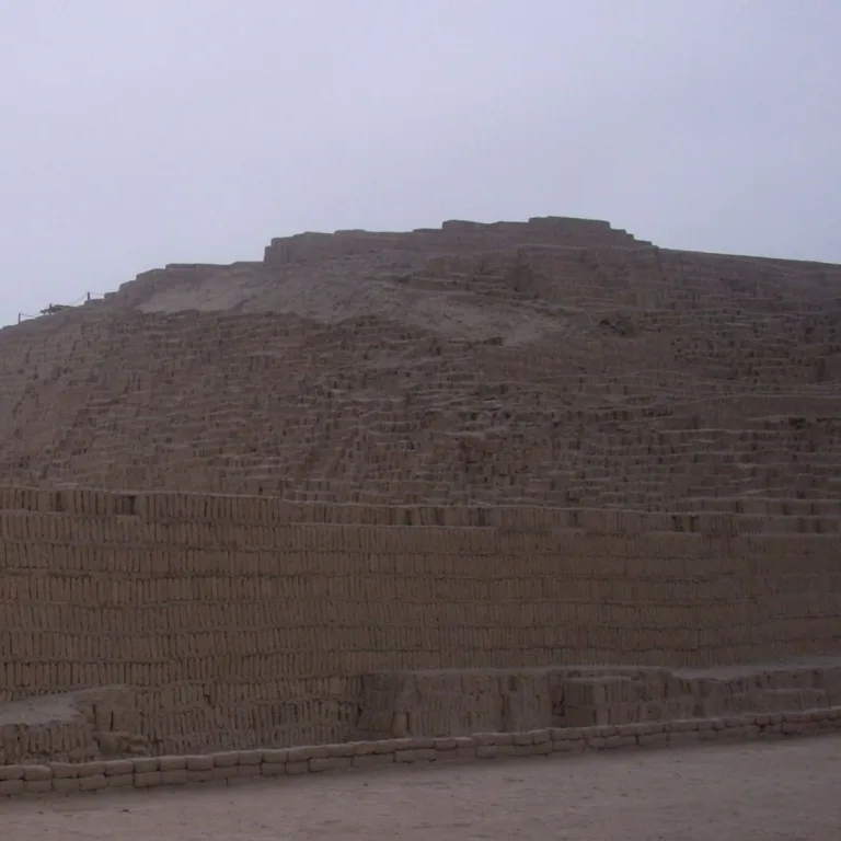 The Gran Pirámide at Huaca Pucllana in Lima, Peru, showing the massive stepped adobe pyramid with numerous horizontal terraces and a broad retaining wall across its lower section.