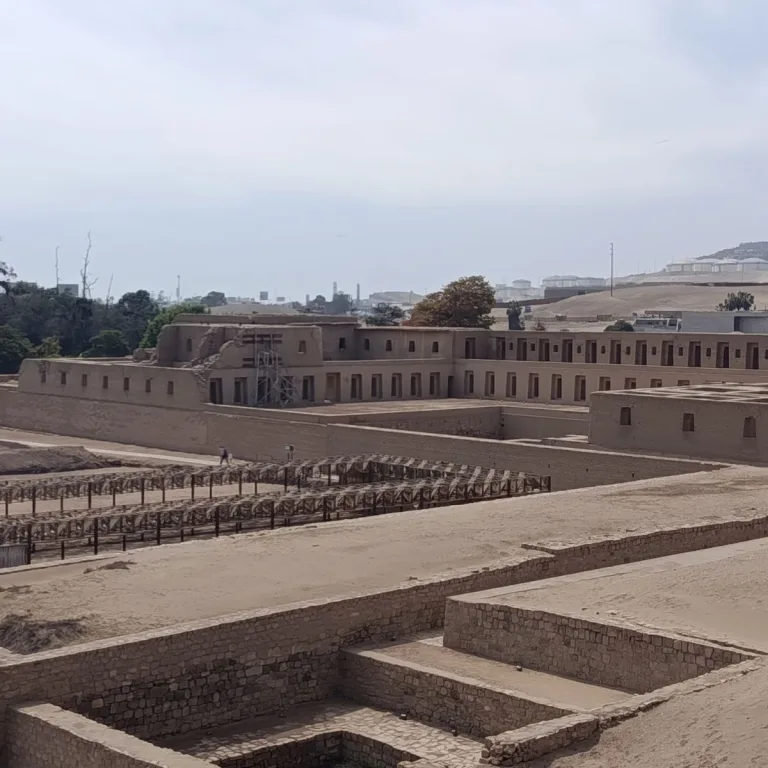 The Acllawasi at Pachacamac, with rows of niches and doorways overlooking a courtyard and sunken stone-lined enclosures.